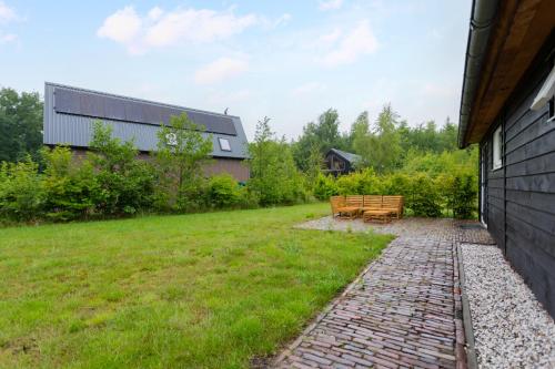 a walkway with two benches next to a building at Boshuisje Luna | 4 personen - Vakantiepark De Kremmer in Gasselte