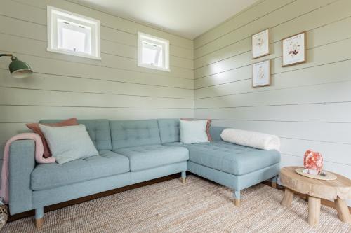 a living room with a blue couch and a table at Boshuisje Luna | 4 personen - Vakantiepark De Kremmer in Gasselte