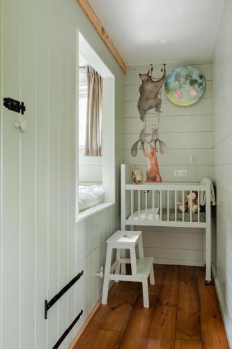 a baby room with a crib and a window at Boshuisje Luna | 4 personen - Vakantiepark De Kremmer in Gasselte