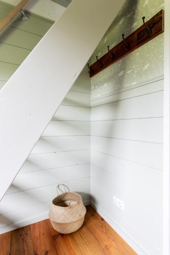 a room with white walls and a basket on the floor at Boshuisje Luna | 4 personen - Vakantiepark De Kremmer in Gasselte