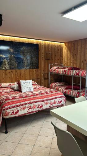a room with two bunk beds and a table at Residenze Vezza - La Corteccia- in Vezza dʼOglio