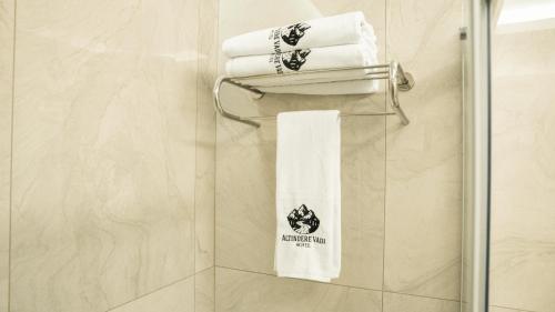 a bathroom with white towels and a towel rack at Altındere Vadi Hotel in Akyazı