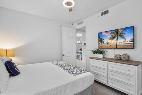 a bedroom with a bed and a tv on a wall at One Happy Condo in Bradenton