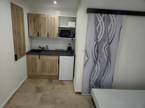 Robion en LuberonにあるCanto Cigalo Rdc 1のシンクと冷蔵庫のある小さなキッチン