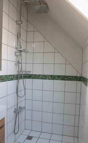 a shower in a bathroom with white tiled walls at Townhouse Hirtshals with sea view in Hirtshals