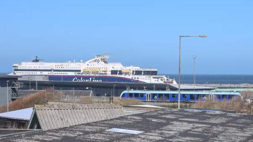 a large cruise ship sitting next to a train at Townhouse Hirtshals with sea view in Hirtshals