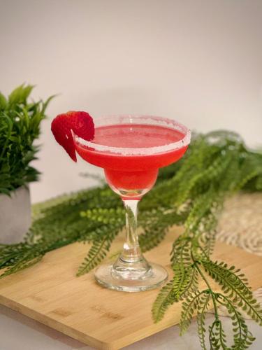 a red drink in a martini glass on a board at Novus Laureles in Medellín