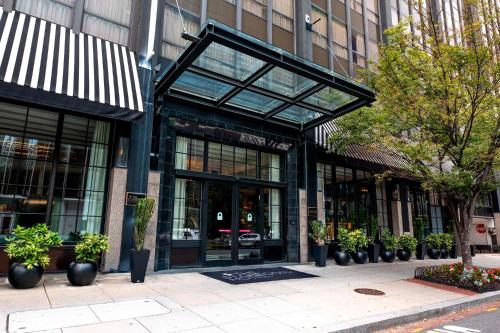 a building with glass doors and potted plants on a sidewalk at Eurostars St Gregory Dupont Circle Georgetown in Washington