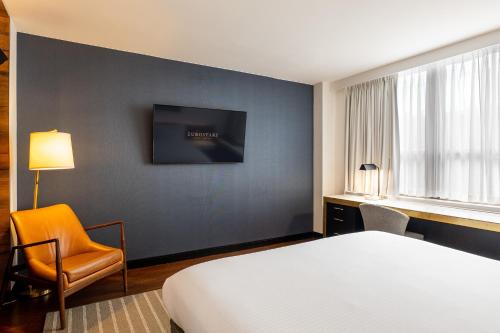 a hotel room with a bed and a chair and a tv at Eurostars St Gregory Dupont Circle Georgetown in Washington