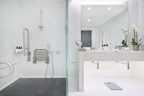 a white bathroom with a shower and a sink at InterContinental Cascais-Estoril by IHG in Estoril