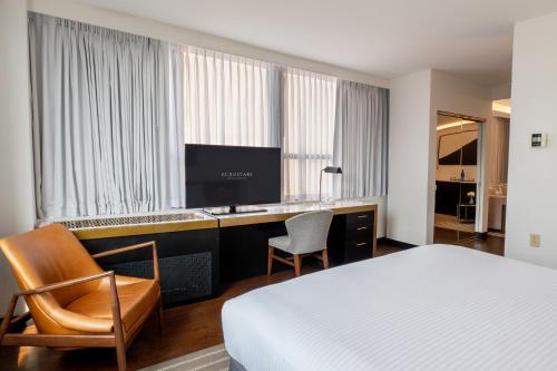 a hotel room with a bed and a desk with a television at Eurostars St Gregory Dupont Circle Georgetown in Washington