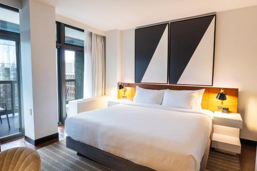 a hotel room with a large white bed and windows at Eurostars St Gregory Dupont Circle Georgetown in Washington