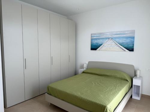 1 dormitorio con 1 cama y armarios blancos en Casa al mare di Nonno Robi, en Fano