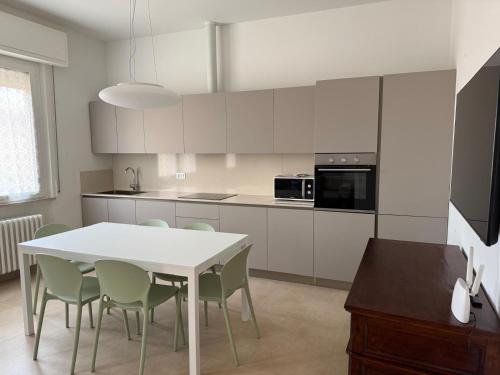 Una cocina blanca con una mesa y sillas blancas. en Casa al mare di Nonno Robi, en Fano