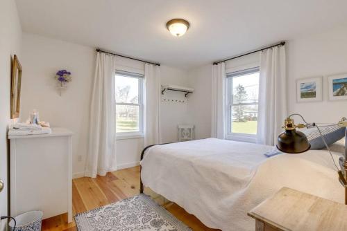 a bedroom with a large bed and two windows at The Prince Edward County Church, A Unique Escape in Belleville