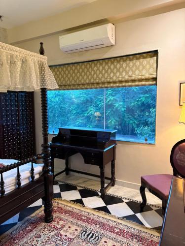 a living room with a piano and an aquarium at Bhanpur Haveli in Dhānd