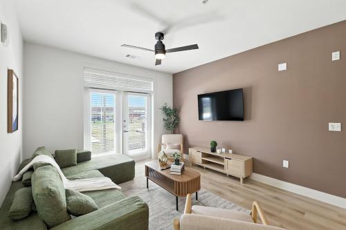 a living room with a couch and a tv at 95 Luxury 2B2B Condo DT Fort Worth, Resort Style Pool & Gym, Golf Simulator, 7M to Dickies Stadium, 15M to AT&T stadium in Fort Worth