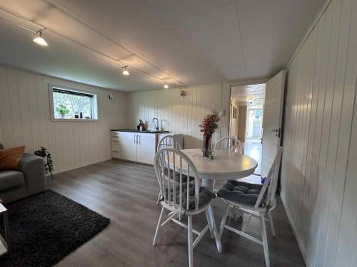 a living room with a table and chairs and a kitchen at Basement apartment in beautiful Volda in Volda