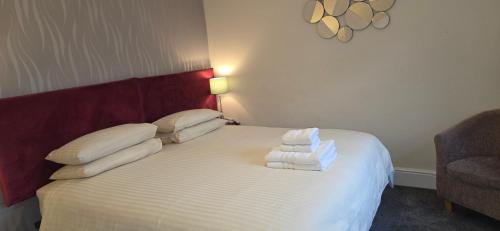 a bedroom with a bed with towels on it at Edward Hotel in Gloucester