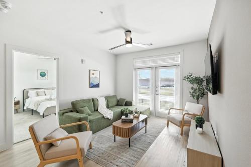 a living room with a green couch and chairs at 95 Luxury 2B2B Condo DT Fort Worth, Resort Style Pool & Gym, Golf Simulator, 7M to Dickies Stadium, 15M to AT&T stadium in Fort Worth