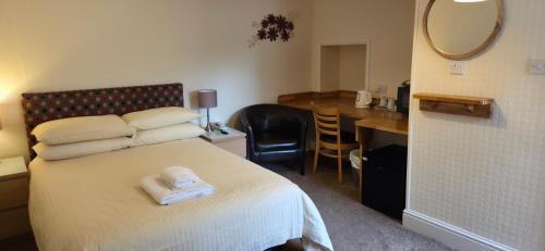 a bedroom with a bed and a desk and a mirror at Edward Hotel in Gloucester