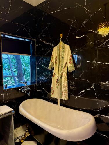 a robe on a hanger above a sink in a bathroom at Bhanpur Haveli in Dhānd