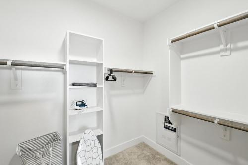 a bathroom with white walls and white shelves at 95 Luxury 2B2B Condo DT Fort Worth, Resort Style Pool & Gym, Golf Simulator, 7M to Dickies Stadium, 15M to AT&T stadium in Fort Worth