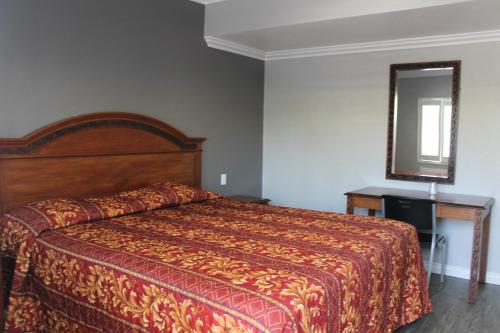 a bedroom with a large bed and a mirror at Town House Motel in Lynwood
