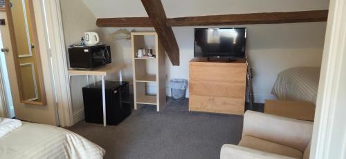 a room with a bedroom with a tv and a bed at Edward Hotel in Gloucester
