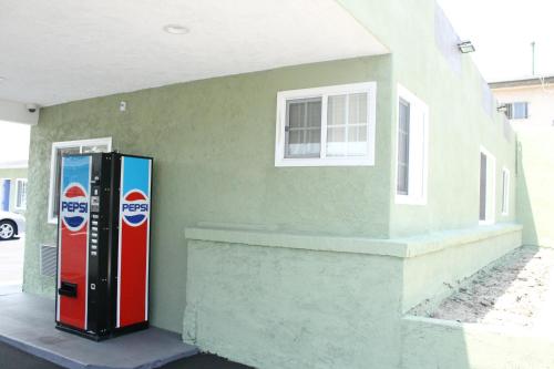 a soda machine is parked next to a building at Town House Motel in Lynwood