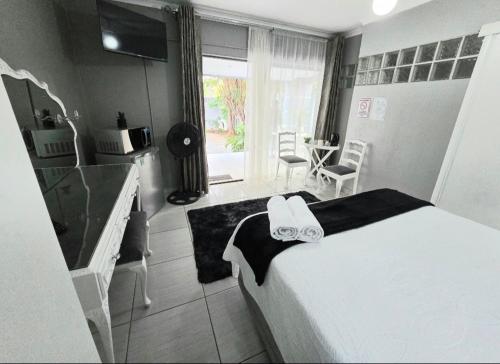 a bedroom with a large white bed with a black and white ribbon at Zhantique Guest House 1- Unit 1 in Boksburg