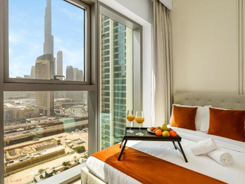 a hotel room with a bed and a window with wine glasses at Stunning Two-Bedroom Apartment with Skyline View & walk to Dubai Mall by TerraHome in Dubai