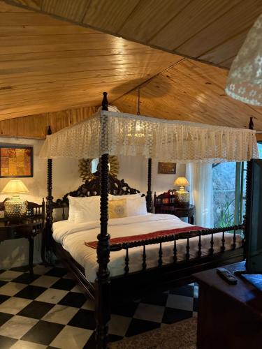 a bedroom with a canopy bed with a checkered floor at Bhanpur Haveli in Dhānd