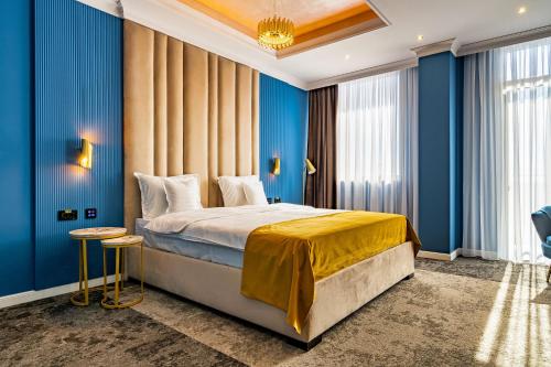a bedroom with blue walls and a large bed at PRESTIGE PLAZA in Suceava