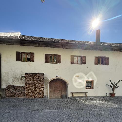 a white building with a wooden door and a bench at HauszumdurstigenEsel in Vna