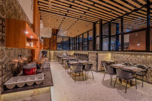 un restaurante con una fila de mesas y sillas en Park Avenue Hotel Bannerghata Road, en Bangalore