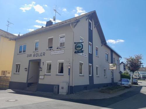 a white building with a sign that reads our buffer at Pension Zum Adler in Limbach