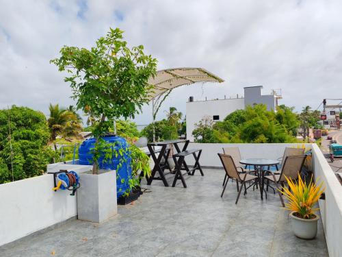 a patio with tables and chairs on a balcony at Lush Lagoon Transit Katunayake in Katunayake