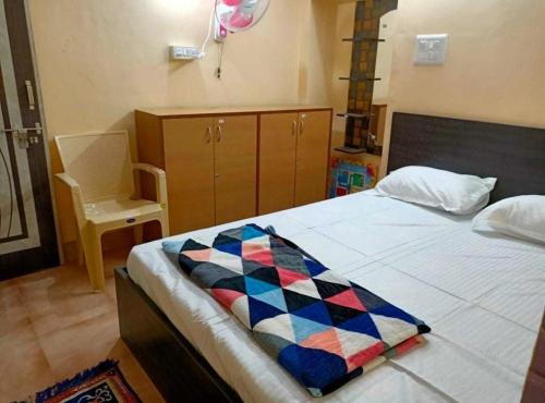a bedroom with a bed with a colorful blanket on it at Malnadu home stay Haandi in Aldūr