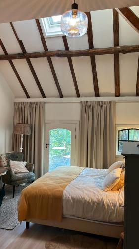 a bedroom with a bed and a chandelier at Logeerkamer Water op Buitenplaats de Burgwal in Leusden