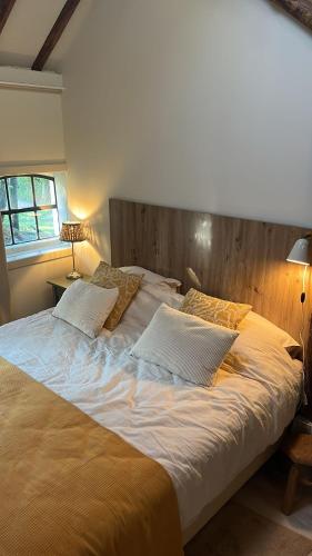 a large bed with two pillows on it in a bedroom at Logeerkamer Water op Buitenplaats de Burgwal in Leusden