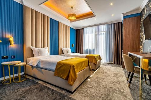 a hotel room with two beds and a desk at PRESTIGE PLAZA in Suceava