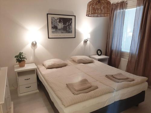 a bedroom with a bed with two pillows on it at Tilava kaksio saunalla in Seinäjoki