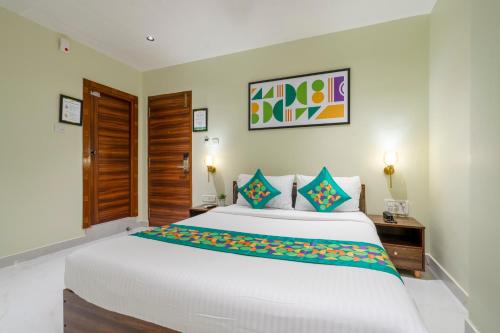 a bedroom with a large white bed with blue pillows at Treebo The Infinity, Banjara in Hyderabad