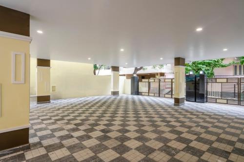 an empty lobby with a checkered floor and columns at Treebo The Infinity, Banjara in Hyderabad