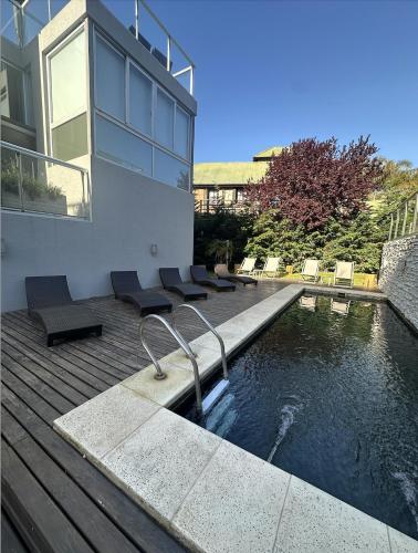 a house with a swimming pool next to a building at Arenas Calidas Carilo in Carilo
