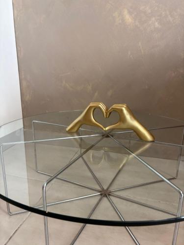 a glass table with a golden object on top of it at The Bright Bridge, Near Sliema with AC in Il-Gżira