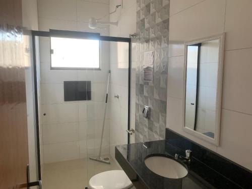 a bathroom with a toilet and a sink and a shower at Linda Casa com piscina Aquecida e área de lazer in Caldas Novas
