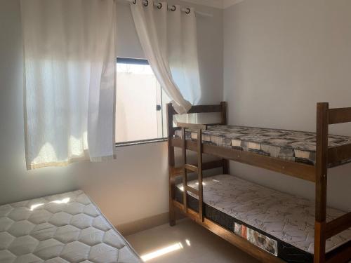 two bunk beds in a room with a window at Linda Casa com piscina Aquecida e área de lazer in Caldas Novas