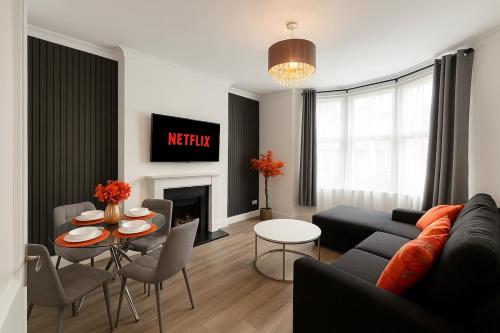 a living room with a couch and a table at Spacious 4Bedroom - 10mins to London Bridge with Parking & Garden in London